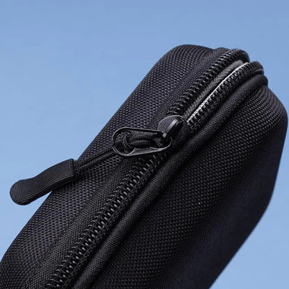 Black zippered pouch against a blue background